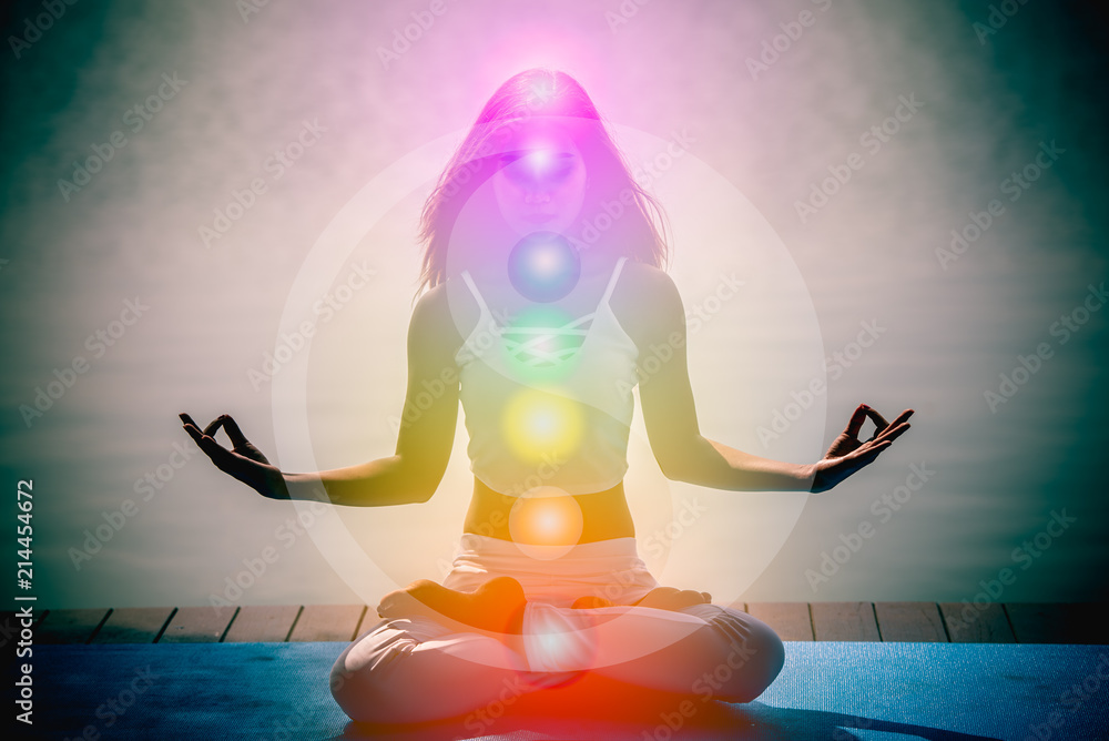 Young woman in yoga meditation with seven chakras and Yin Yang symbols.